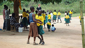 Kinder und Volunteer vor der Schule